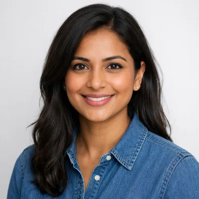A photorealistic, professional headshot of a diverse adult with a warm, friendly expression against a soft white background.